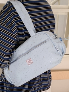 Light blue star pattern shoulder bag tote with drawstring detail worn by a model