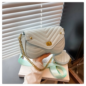 Close-up of mint green quilted crossbody bag with golden twist lock and round coin purse