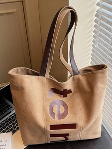 Sac cabas en toile marron avec poignées en cuir et imprimé lettres dans un bureau moderne