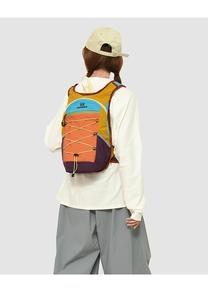 Detail of color-blocked nylon backpack with yellow bungee cords and zip pocket