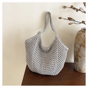 Close-up of the light gray hand-woven hollow mesh texture of a boho tote beach bag