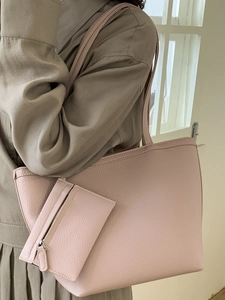 Pink lychee texture tote bag with inner pouch worn by model in trench coat