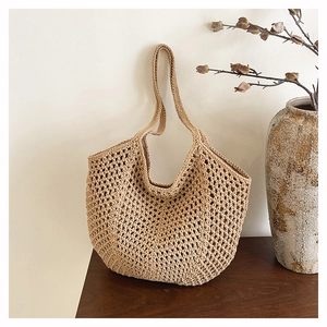 Close-up of hand-woven straw tote bag texture with natural brown fibers on wood