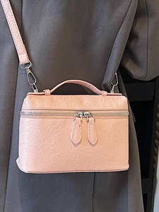 Chic pink ostrich texture box handbag worn as a stylish crossbody shoulder bag