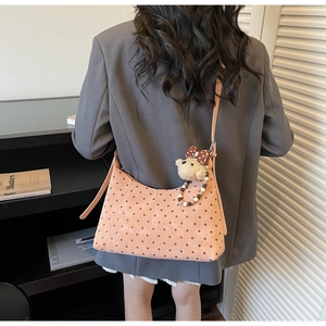 Close-up of pink polka dot crescent moon hobo bag with cute plush bear charm detail
