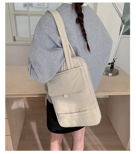 Close-up of quilted nylon tote bag in beige with large front pocket and padded texture