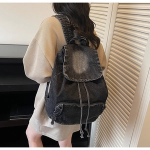 Close-up of retro denim backpack showing thick fabric texture and drawstring closure