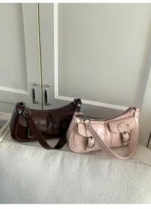 Dettaglio di borse baguette stile vintage marrone scuro e beige con doppie tasche