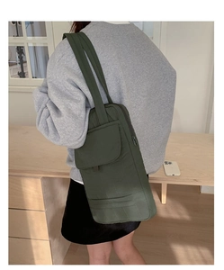 Detail of olive green quilted nylon shoulder bag with side zipper and flap pocket