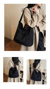 Detail of black corduroy hobo bag showing ribbed texture and functional front flap pocket