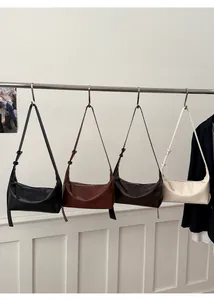 Detail view of baguette bags in black, caramel brown, dark coffee and off-white colors