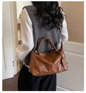 Brown leather slouchy shoulder bag with gold hardware and side decorative tag
