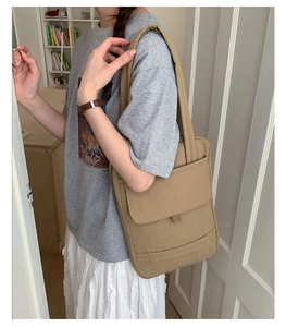 Detail view of khaki tote bag with front flap pocket and reinforced stitching for daily use