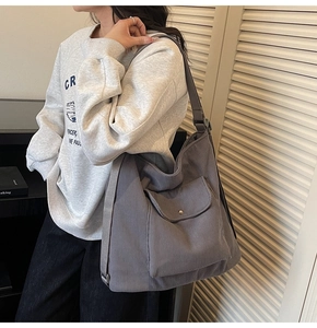 Detail view of large corduroy tote bag in dark grey with adjustable strap and pocket