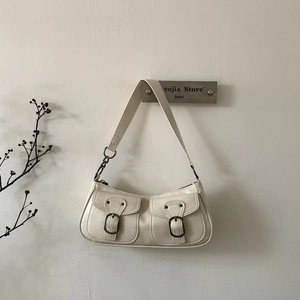 Dettaglio della borsa sottobraccio vintage bianco crema con doppie tasche e fibbie in metallo