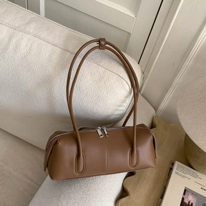 Detail of a vintage dark brown leather cylinder shoulder bag with silver double metal zippers