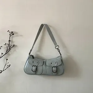Dettaglio borsa a spalla in pelle verde menta con fibbie vintage e doppie tasche frontali