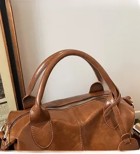 Close-up of the vintage brown leather handbag showing detailed stitching and golden hardware