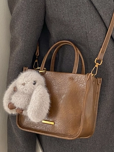 Brown leather tote bag with PANTOUR logo, detachable strap and plush bunny pendant detail