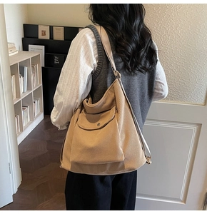 Brown corduroy tote bag showing large capacity and shoulder strap on a model back
