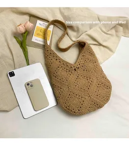 Close-up of beige woven tote bag with hollow floral patterns and hobo style shoulder strap