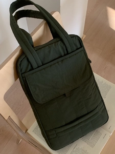 Dark green quilted tote bag with double handles, minimalist style for commuting and tablets