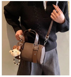 Deep brown retro bowling bag with a cute teddy bear charm shown from a top-down view