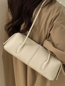 Minimalist beige cylindrical shoulder bag with fine texture and vertical stitching