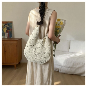 Detailed close-up of handmade off-white woven tote bag with hollow floral patterns