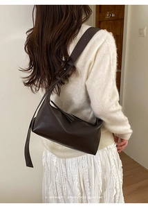 Deep brown minimalist baguette shoulder bag shown in a lifestyle setting with retro vibe