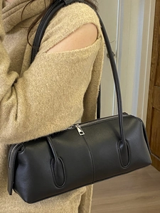 Minimalist black pebble leather baguette shoulder bag for women with sleek silver hardware