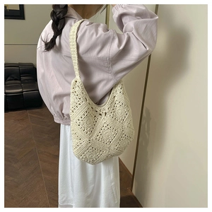 Detail of cream handmade crochet hobo bag showing intricate woven patterns and soft texture