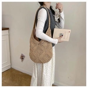 Detail view showing hollow crochet floral pattern on a large woven hobo shoulder bag