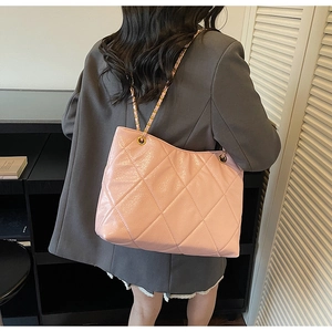 Détail du sac cabas rose matelassé avec finition brillante et chaîne dorée
