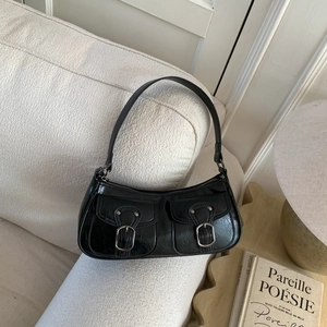 Dettaglio della borsa a spalla in pelle nera vintage con fibbie argentate e taschine
