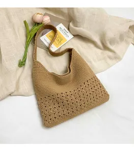 Close-up of beige crochet knit shoulder bag showing hollow-out texture on fabric