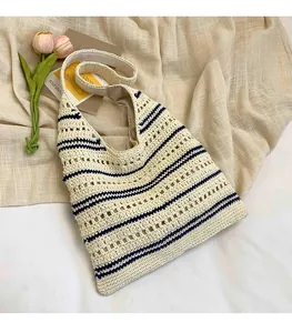 Detail of woven crochet tote bag with navy blue stripes and hollow knit texture