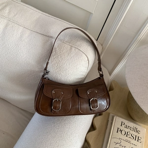 Dettaglio borsa a tracolla marrone vintage con doppie tasche e fibbie in metallo lucido