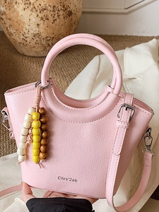 Pink lychee texture bucket bag with round handle and colorful bead charm decoration
