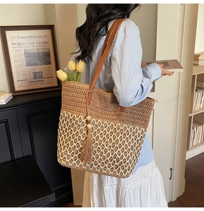 Close-up of large straw tote bag with color blocking details and decorative tassels