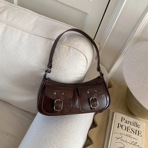 Vista dettagliata della borsa a spalla vintage marrone scuro con tasche a fibbia in pelle
