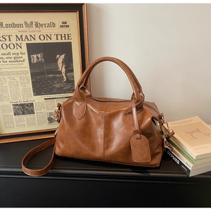 Close-up of vintage brown large capacity handbag with gold hardware and leather texture