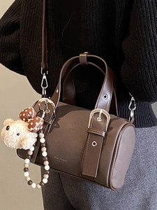 Vintage dark brown leather bowling bag with plush bear charm and adjustable shoulder strap