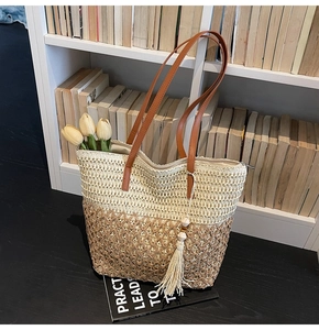 Detail of woven tote bag featuring color-block design, PU handles, and tassel pendant
