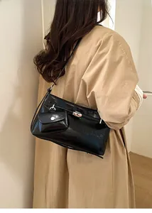 Borsa tote nera lucida con chiusura a scatto argento e mini tasca su cappotto beige