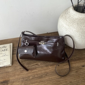 Dettaglio di una borsa marrone vintage con chiusura in argento e mini pochette