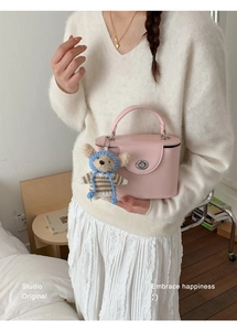 Pink matte leather mini square handbag with silver twist lock and plush bear pendant detail