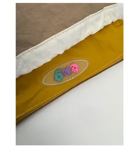 Close-up of a tricolor fabric bag with cartoon patch and smooth zipper detail