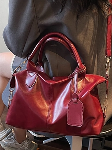 Red large capacity faux leather tote bag with gold hardware and shoulder strap on model