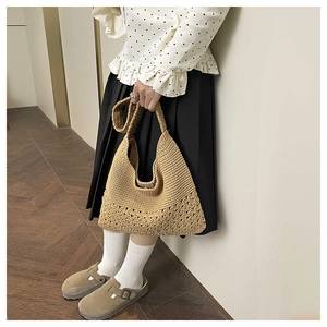 Detailed texture of beige crochet knit tote bag with floral hollow patterns on surface